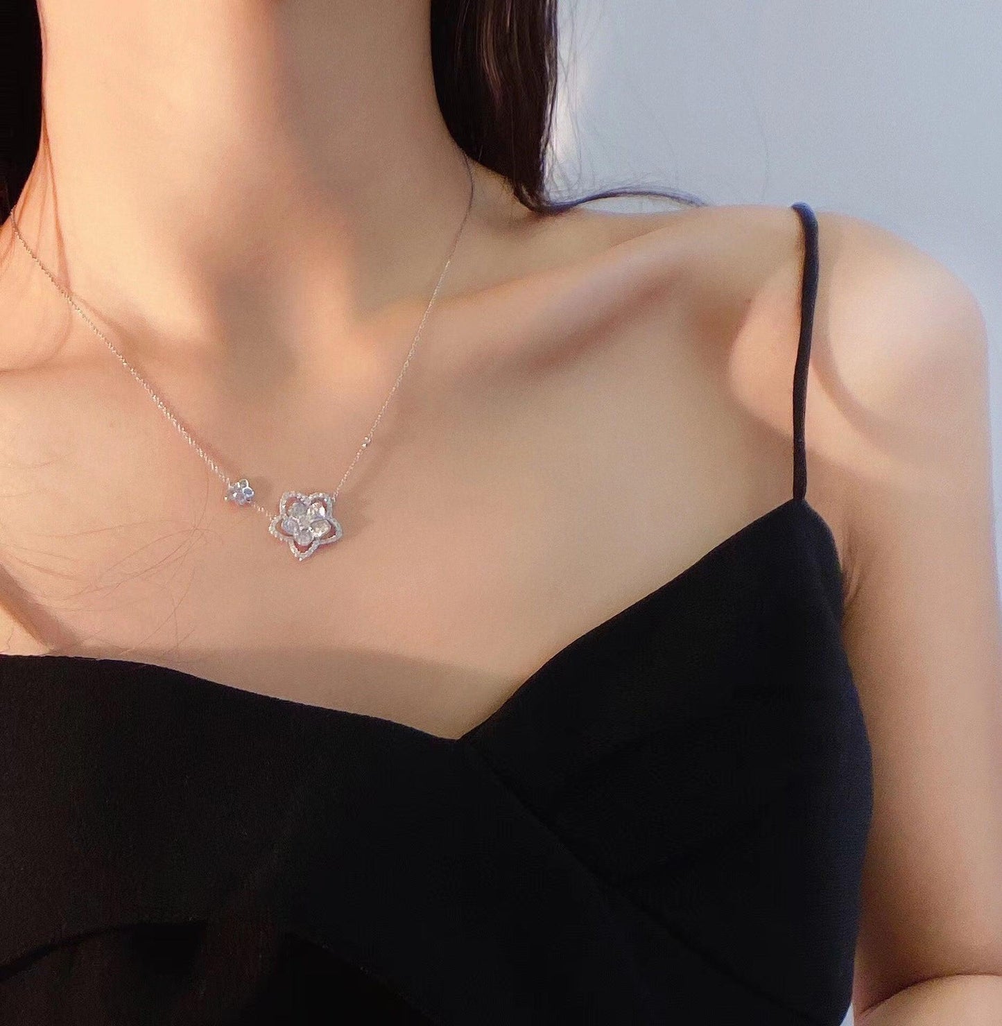 Elegant silver flower necklace with sparkling stones, worn by woman in black top, Sydney jewellery