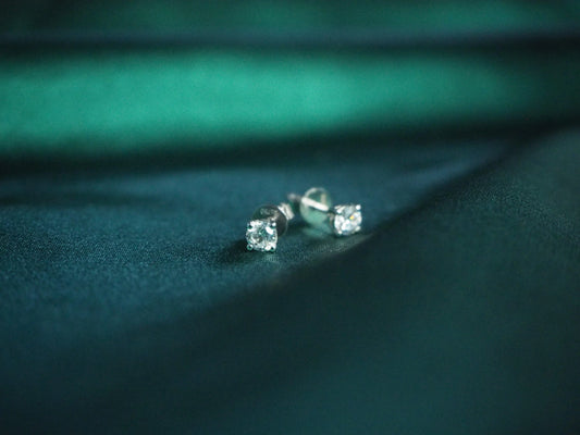 Sparkling diamond stud earrings on dark teal fabric, elegant Sydney jewellery