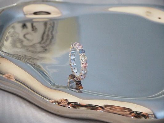 Elegant multi-stone ring with pastel gems on reflective display, Sydney jewellery