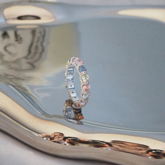 Elegant multi-stone ring with pastel gems on reflective display, Sydney jewellery