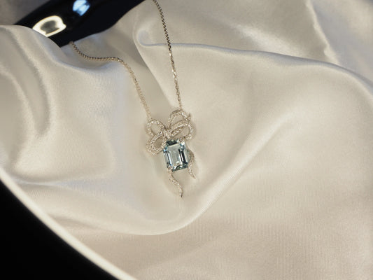 Elegant bow pendant necklace with aquamarine gemstone and diamond accents on silk, Sydney jewellery