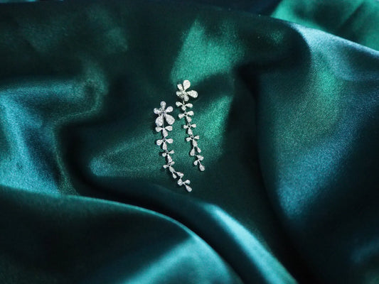Elegant floral drop earrings with sparkling stones on green satin, perfect for Sydney jewellery lovers.