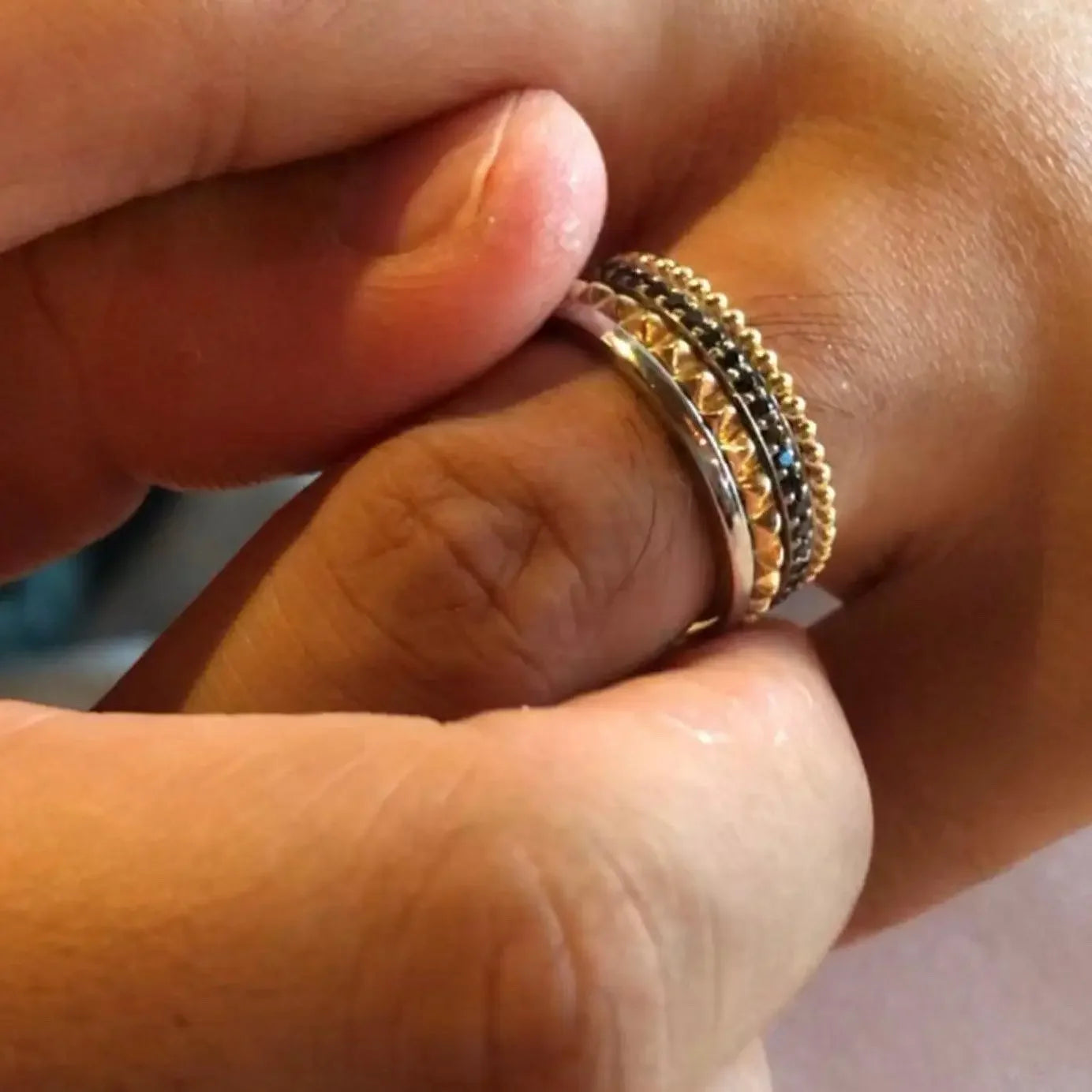 Stacked gold and silver rings with black gemstones on finger, elegant Sydney jewellery design