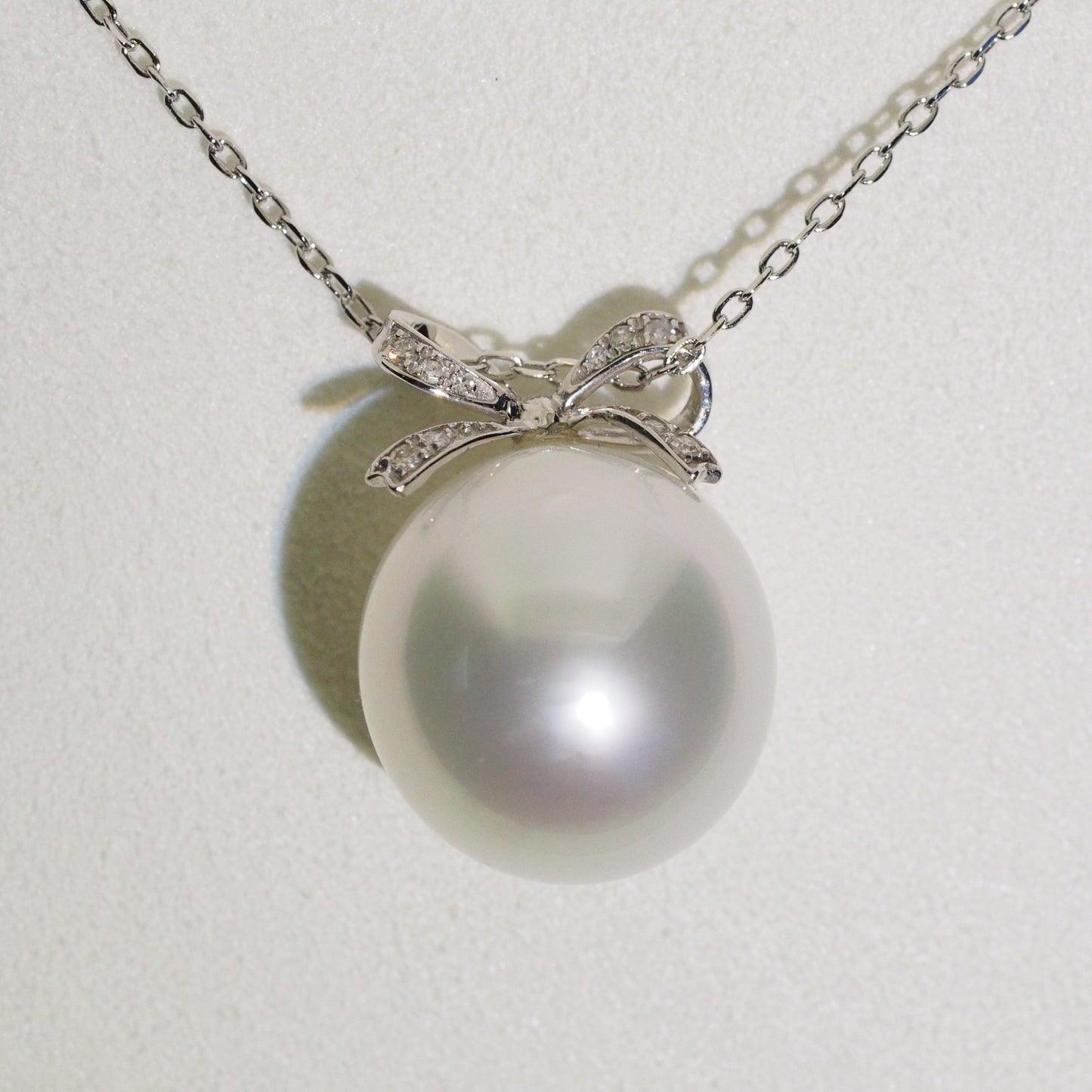 Diamond bow pearl pendant close-up — platinum AAA lustre | Tayam Jewellery Sydney