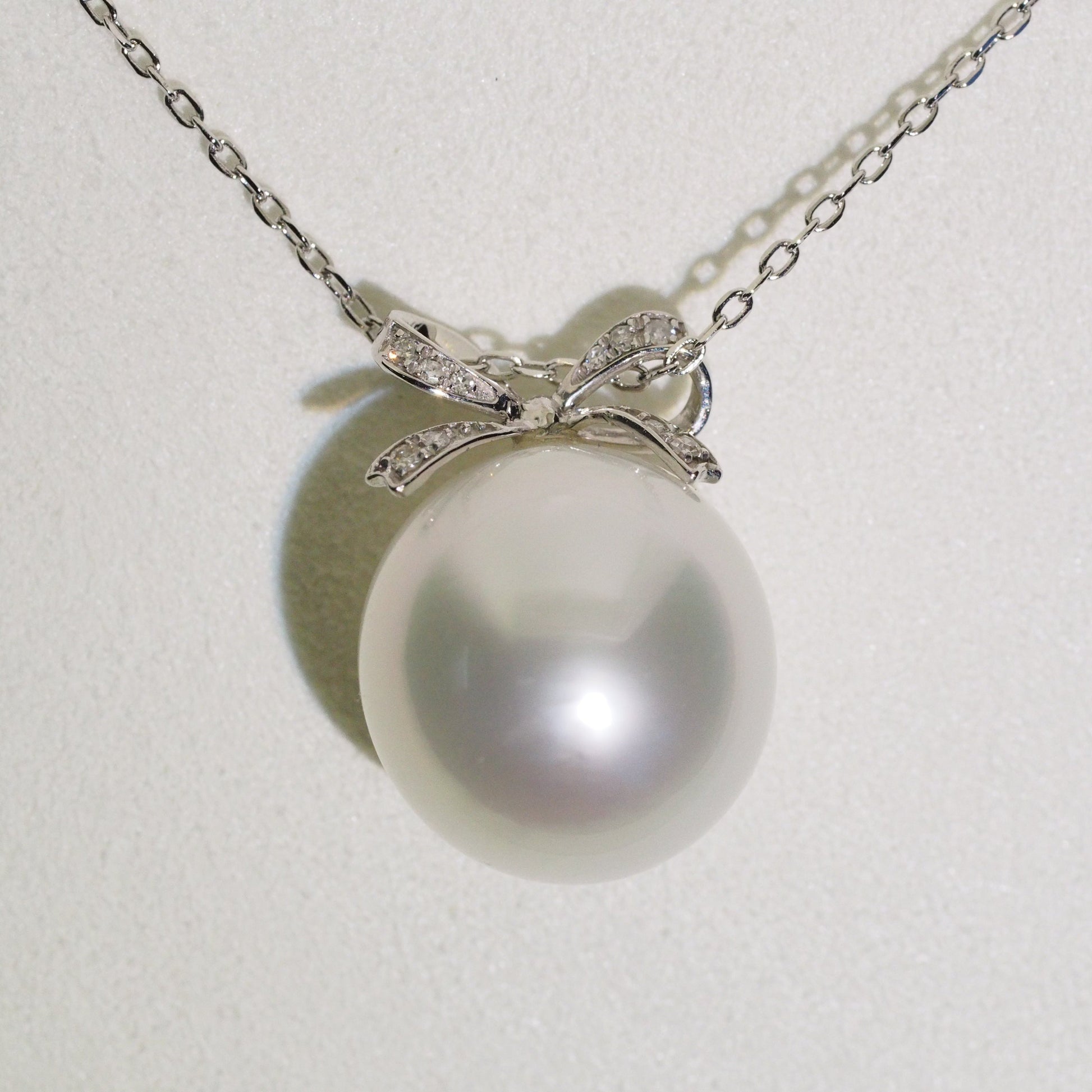 Diamond bow pearl pendant close-up — platinum AAA lustre | Tayam Jewellery Sydney